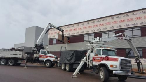 A couple of trucks are parked in front of a building.