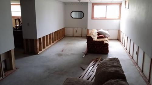 A living room with a couch and a mirror on the wall.