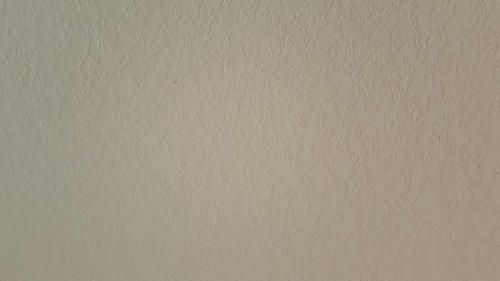 A close up of a white wall with a grainy texture.
