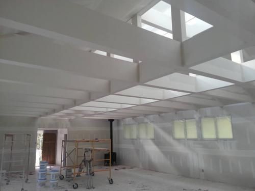 The sun is shining through the ceiling of a building under construction.