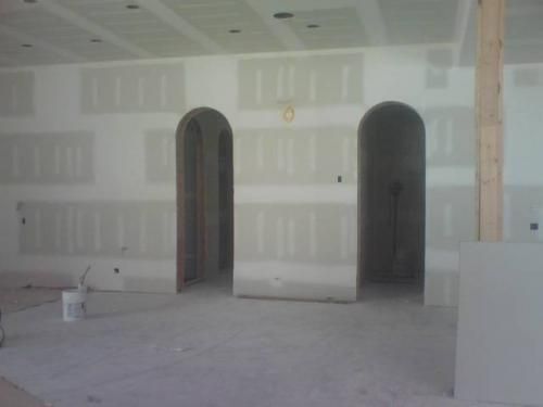 A room with a lot of drywall and arches in it