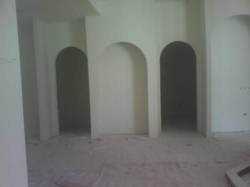 A room with arches on the walls and a carpeted floor.