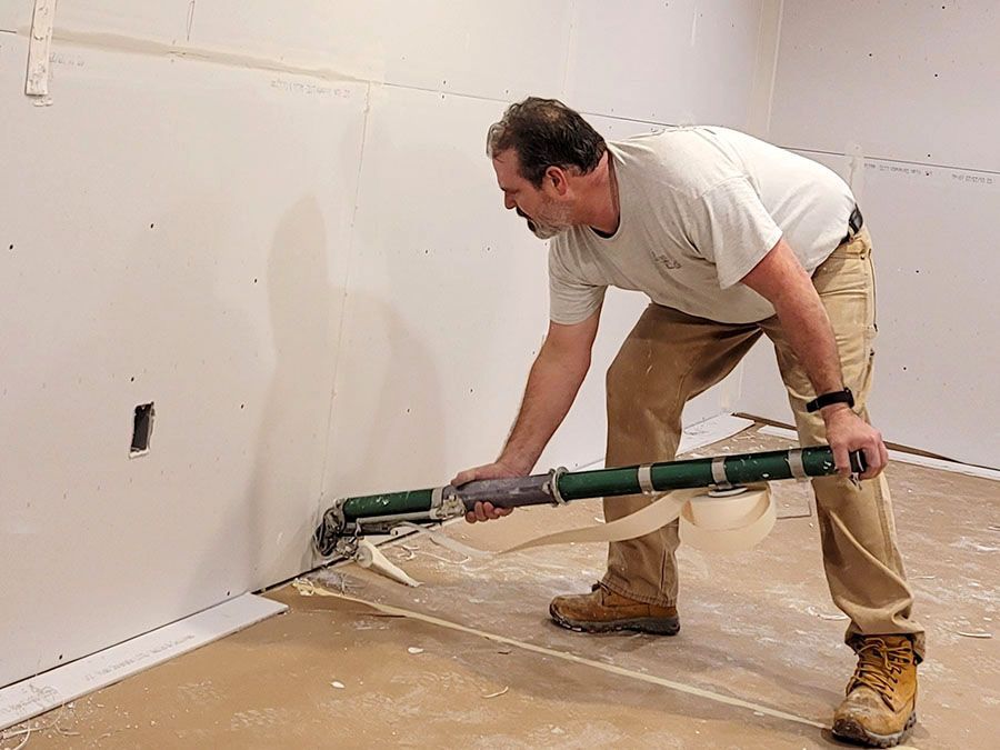 A man using an automatic drywall taper