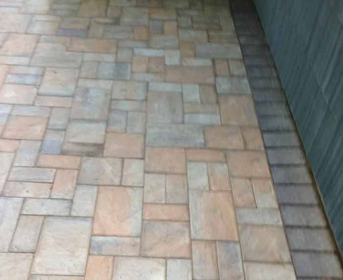 A brick walkway next to a building with a brick border