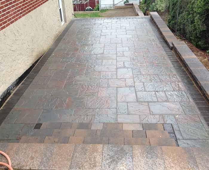 A brick walkway is being built in front of a brick building.