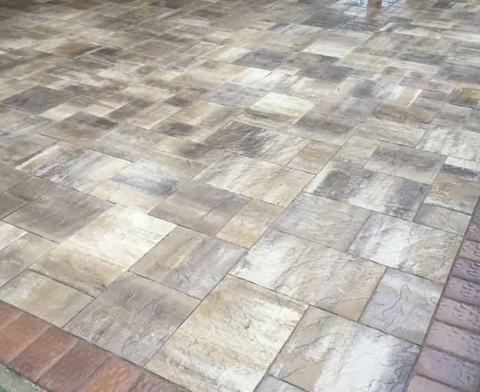 A close up of a brick pavement with a brick border.