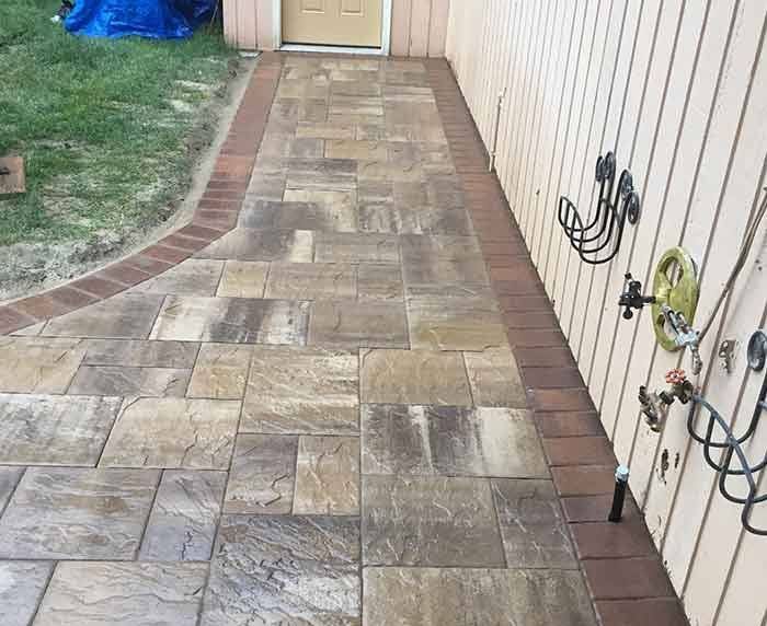 A close up of a brick pavement with a brick border.