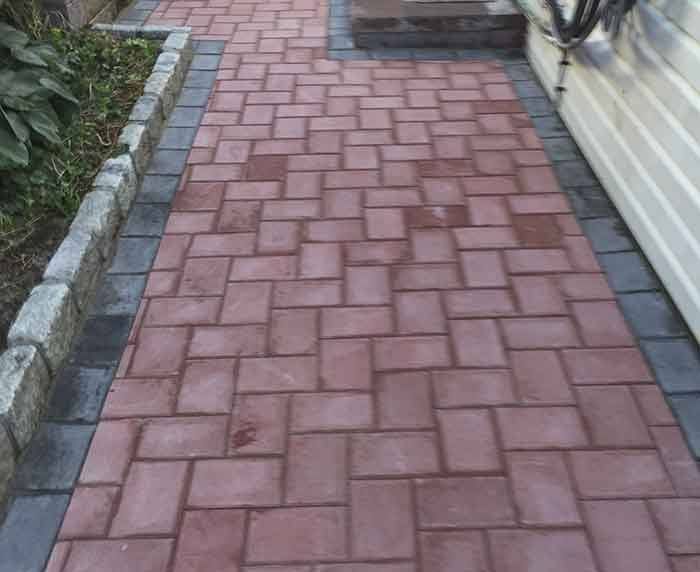 A walkway made of red bricks and black bricks