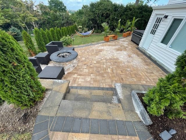 A patio with a fire pit and stairs leading to it