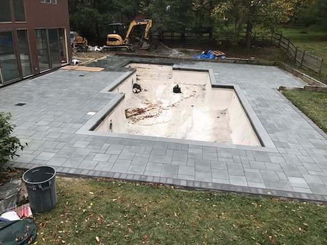 A large swimming pool is being built in a backyard