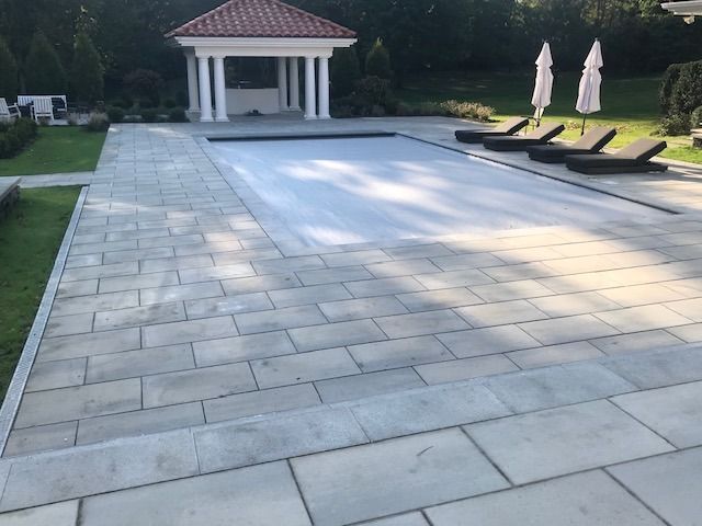 A large swimming pool with a gazebo in the background