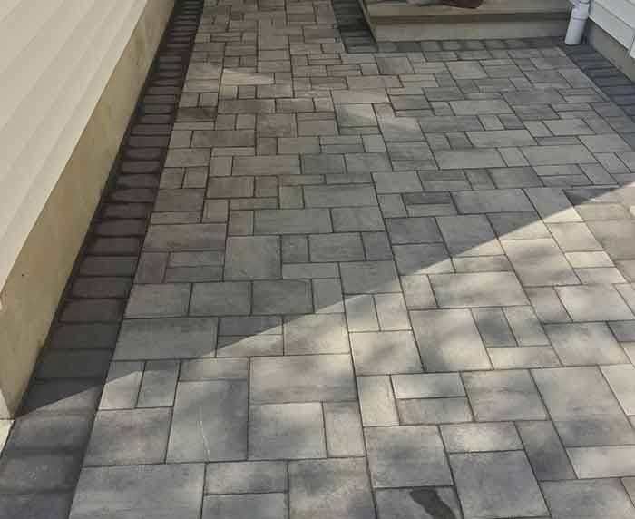 A brick walkway leading to the front door of a house.