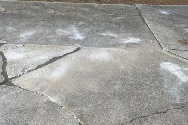 A close up of a concrete driveway with white paint on it.