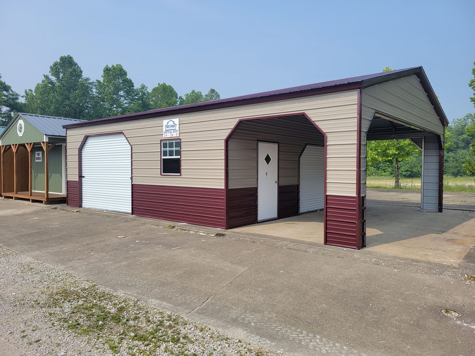 Tan and burgundy metal storage building with two garage bays and a carport.