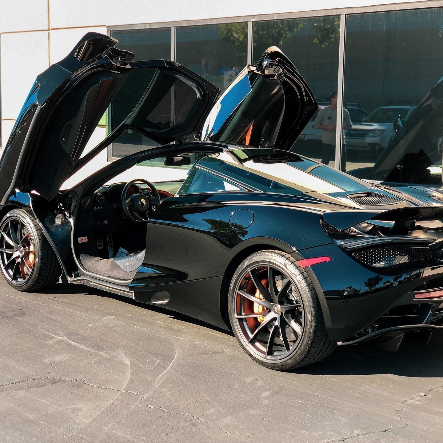 Black McLaren convertible with doors open.