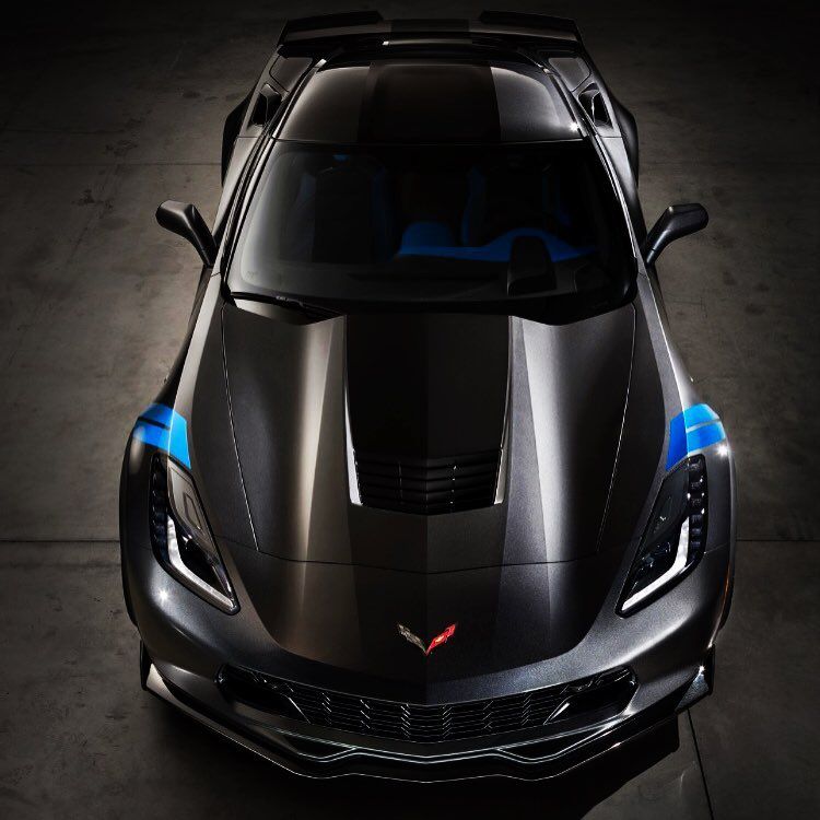 Black Corvette sports car with blue accents on a dark surface, viewed from above.