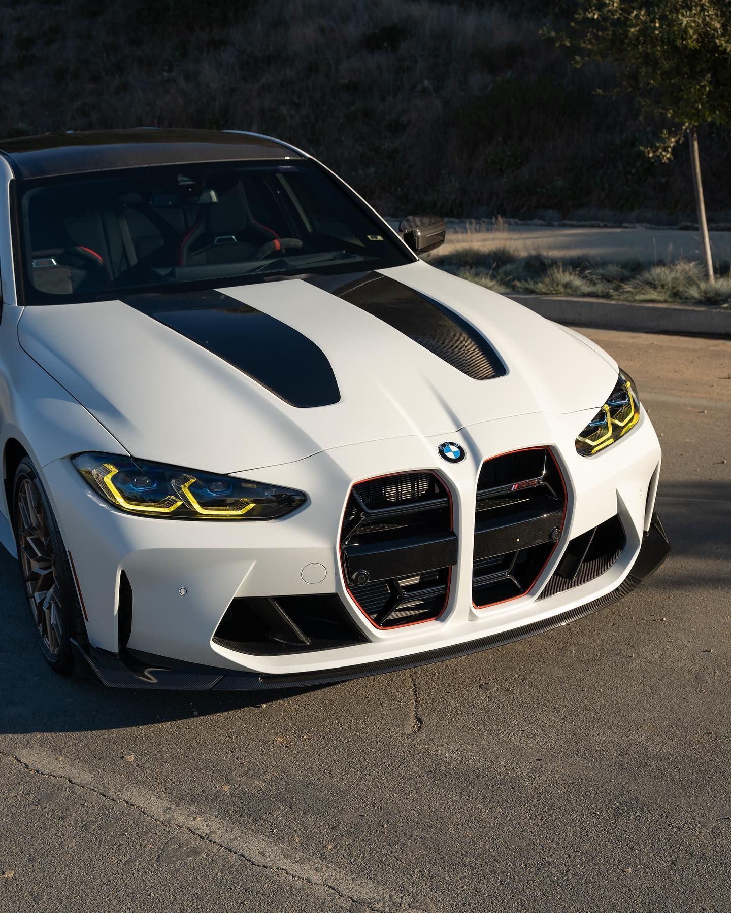 White BMW M3 with black accents parked on asphalt.