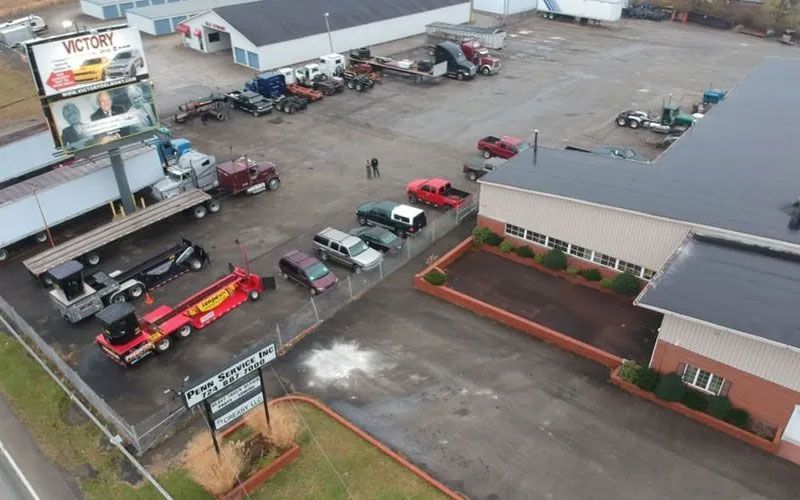 An aerial view of a parking lot with trucks and cars parked in front of a building.