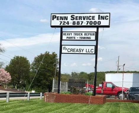 A penn service inc sign with a red truck in the background