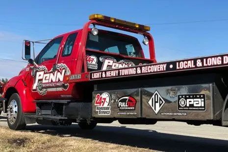 A red tow truck is parked on the side of the road.