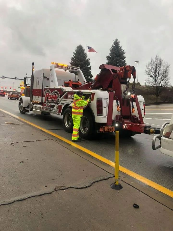 A tow truck is parked on the side of the road.