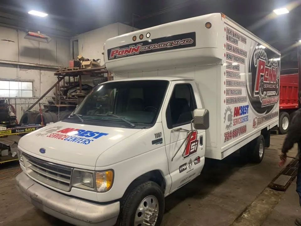 A white truck is parked in a garage.