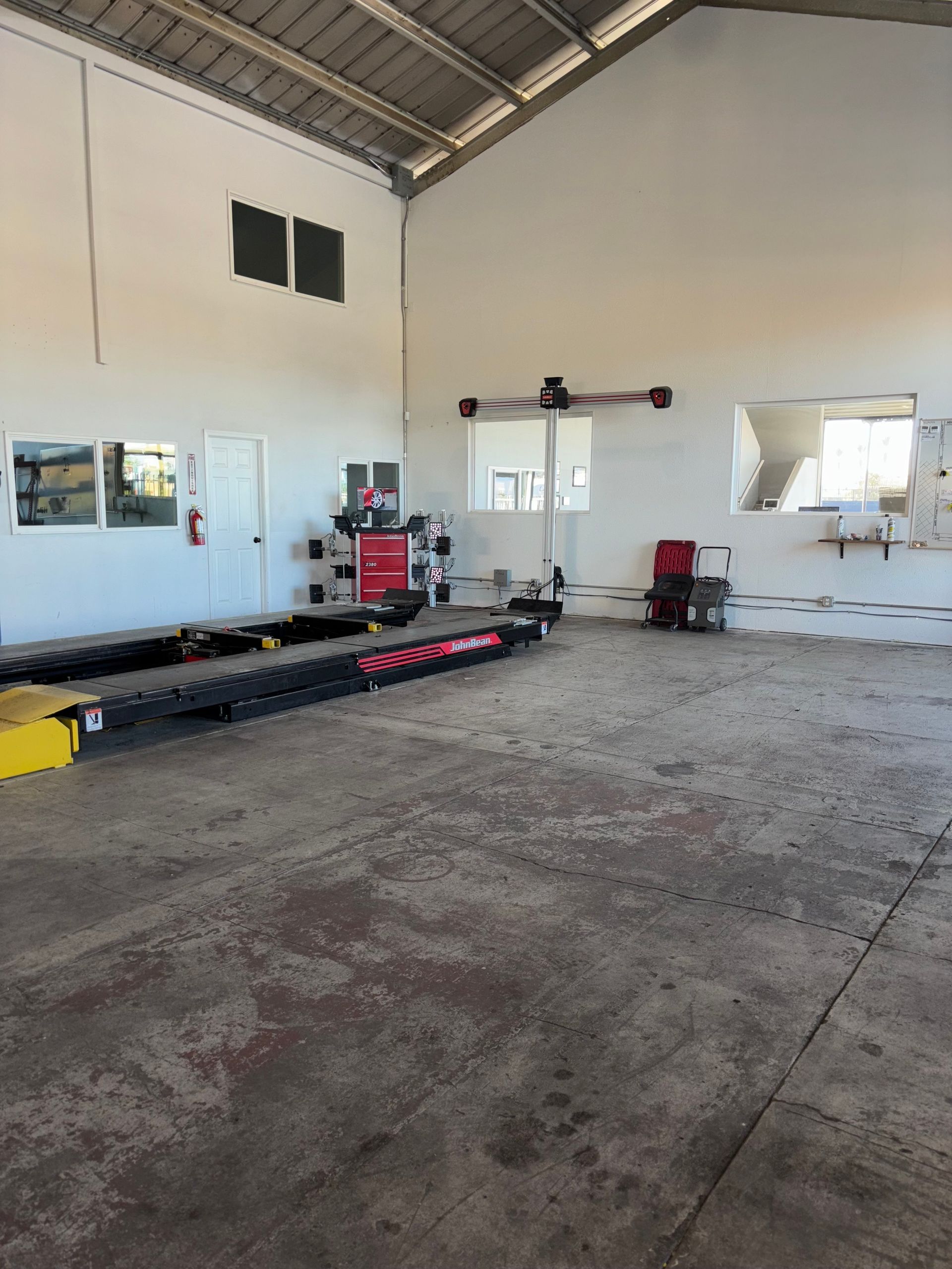 A large empty garage with a lift in the middle of it.
