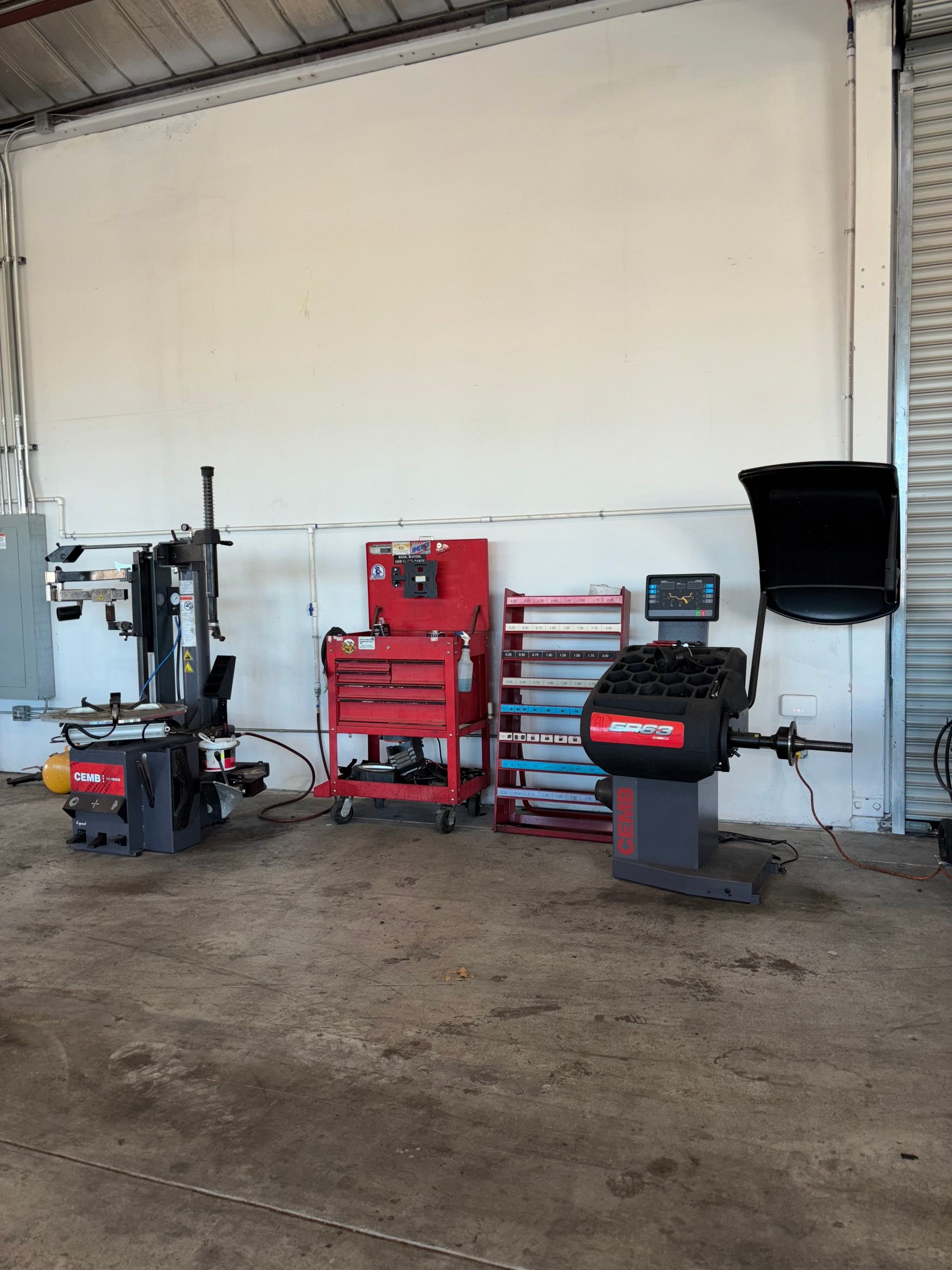 A tire balancing machine is sitting in a garage.