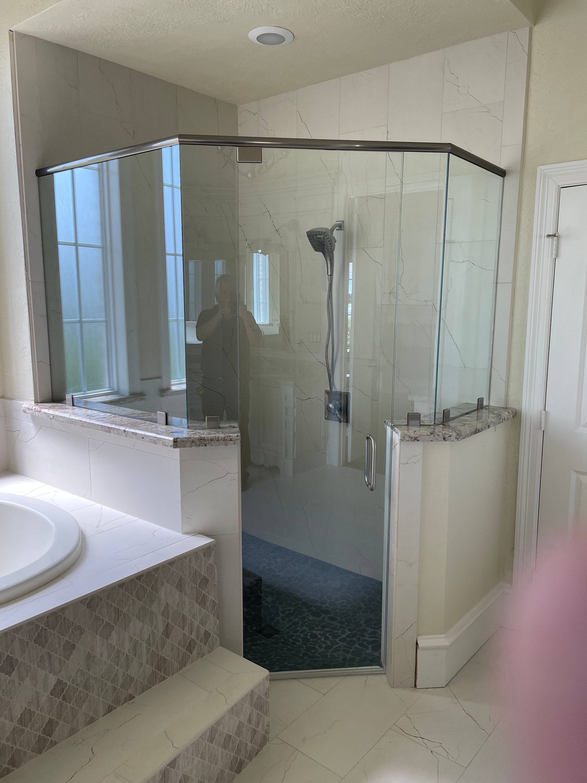 A bathroom with a tub and a shower with a glass door