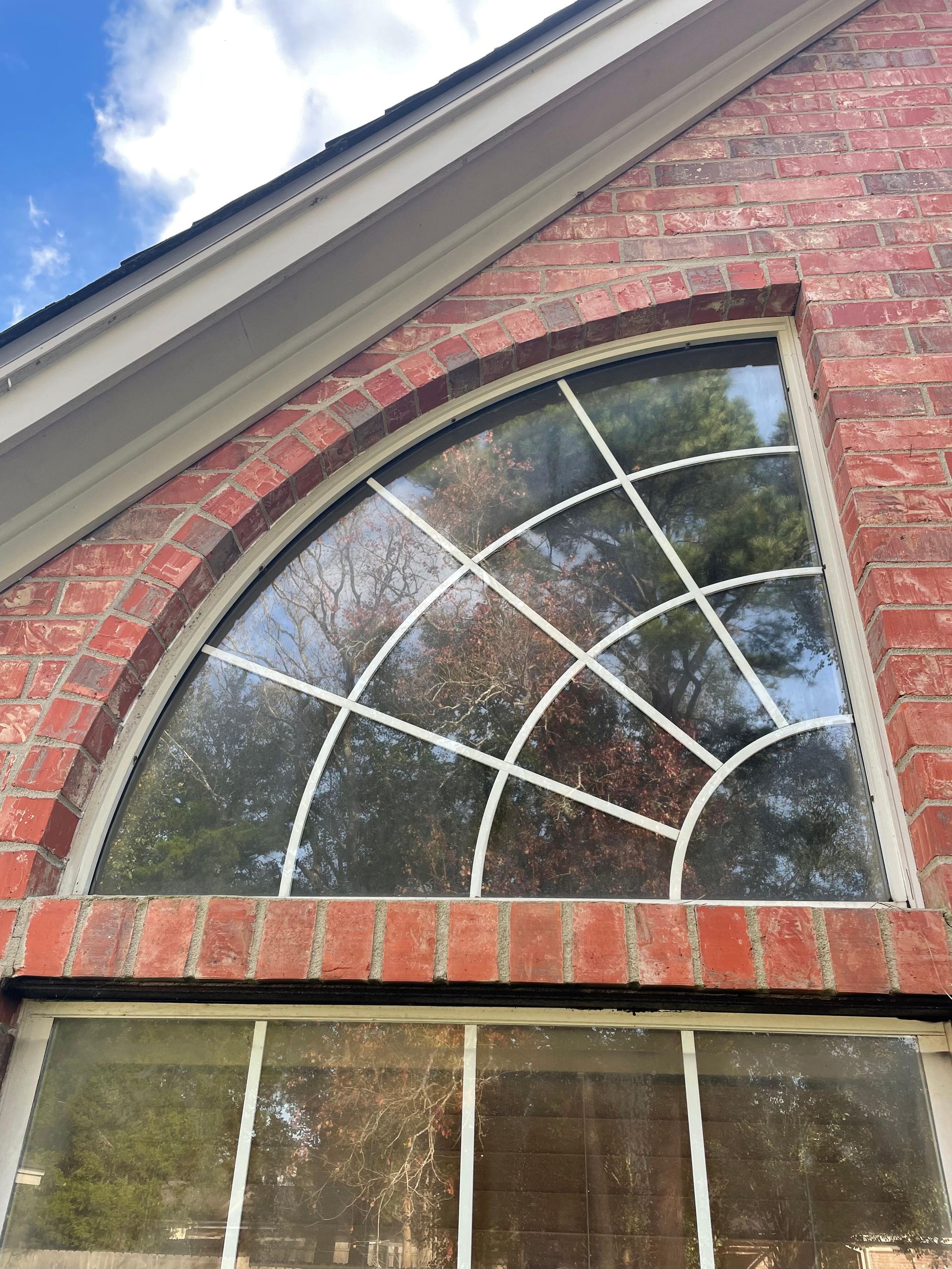 A large arched window on the side of a brick building.