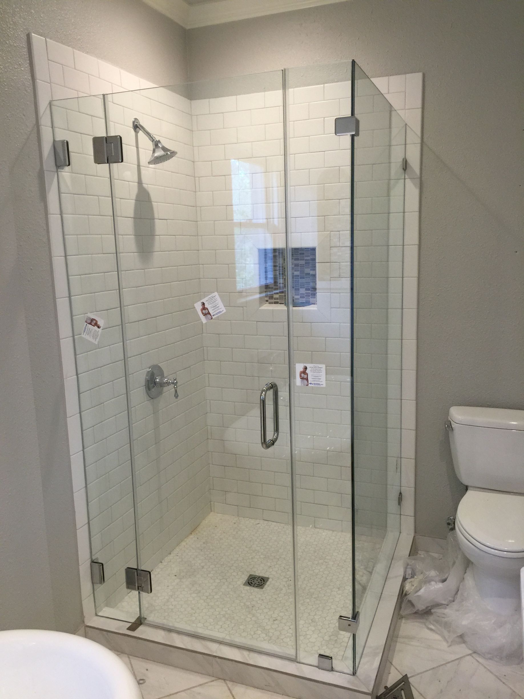 A bathroom with a walk in shower and a toilet.