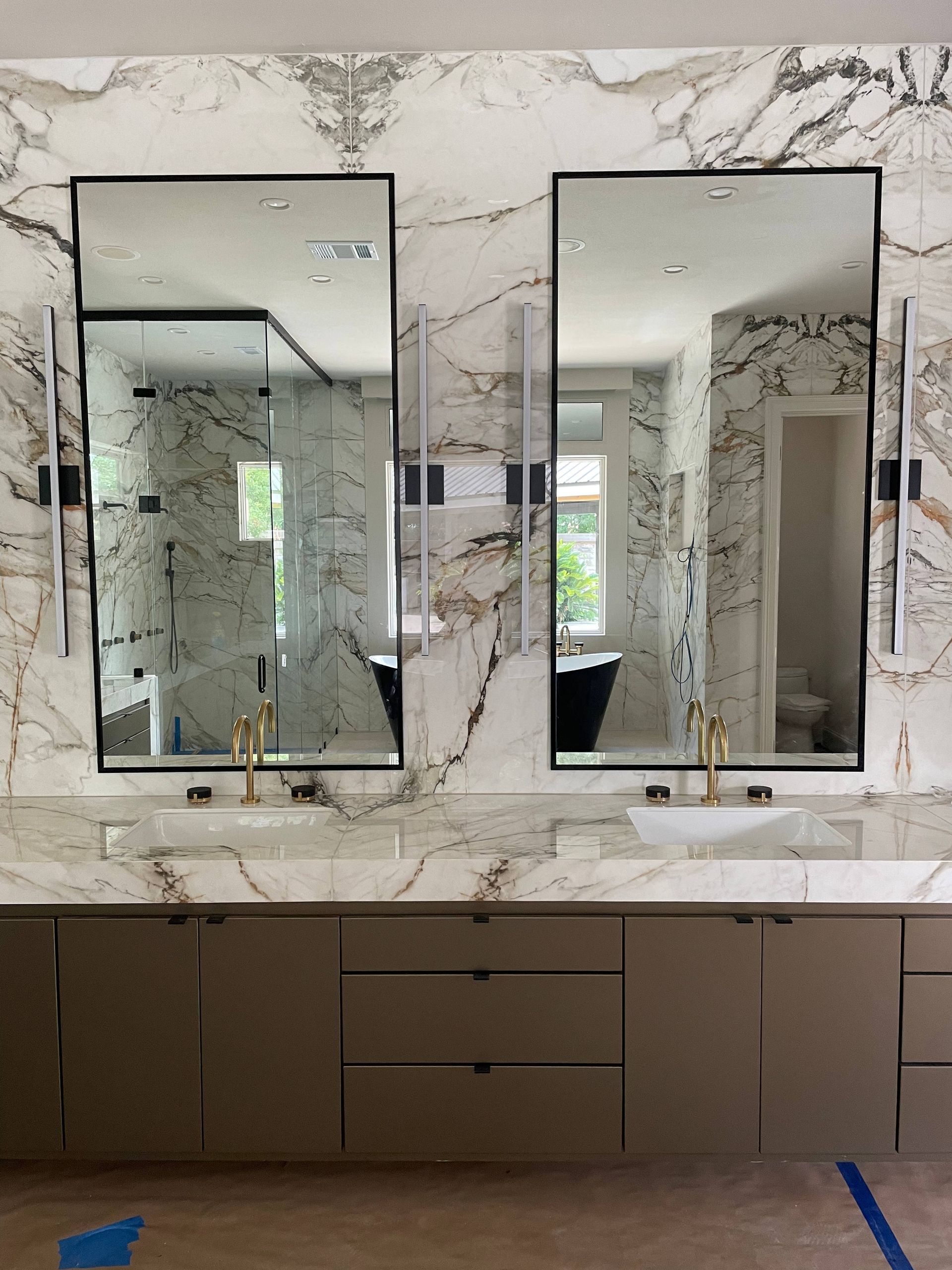 A bathroom with two sinks and two mirrors on the wall.