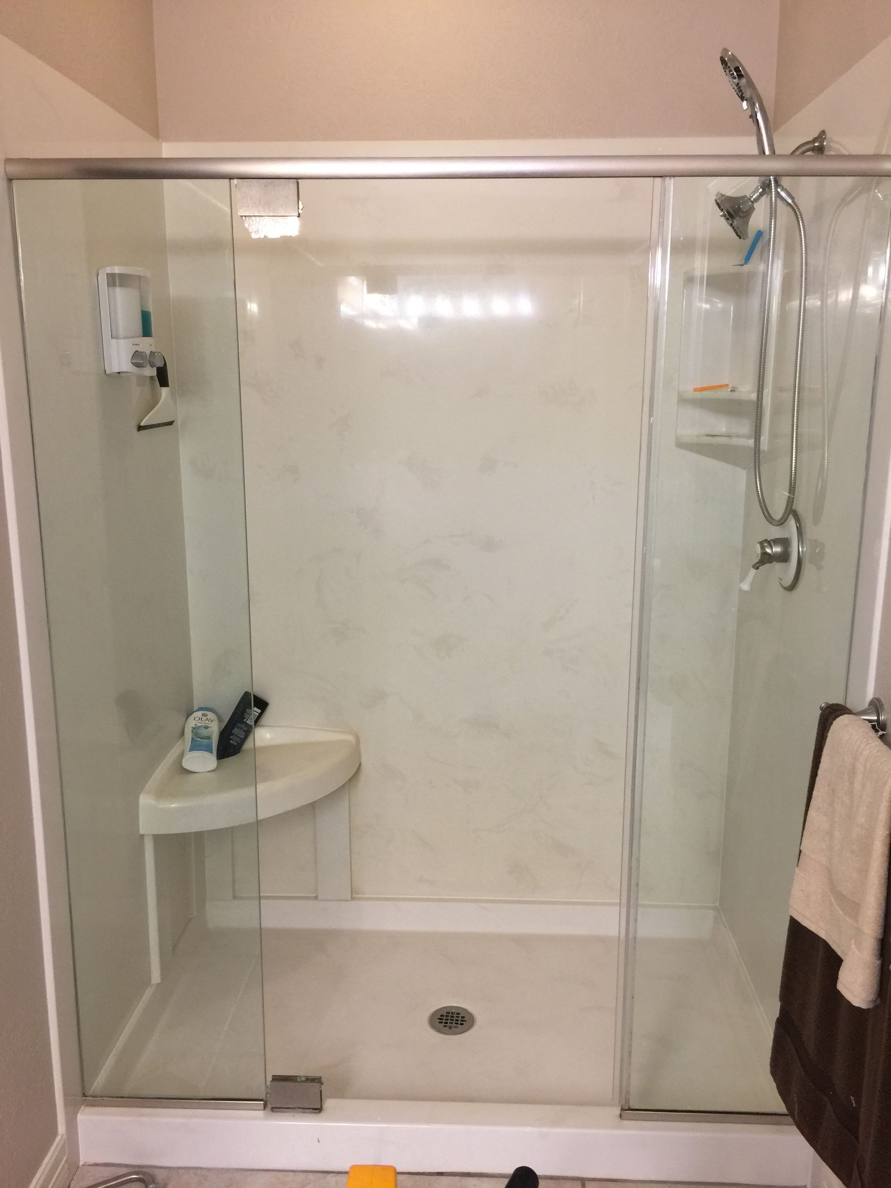 A bathroom with a shower with a sliding glass door