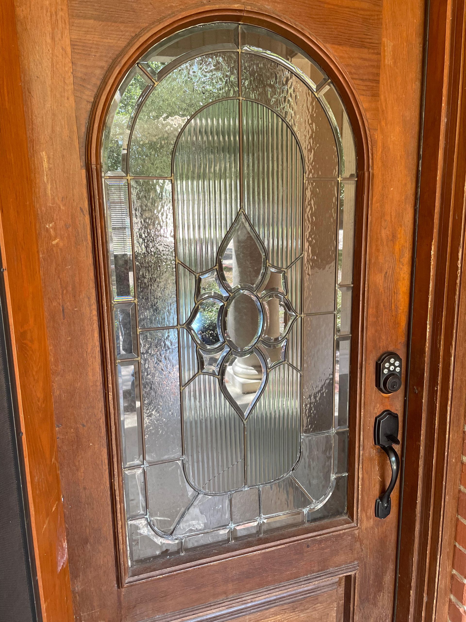 A close up of a wooden door with a stained glass window.