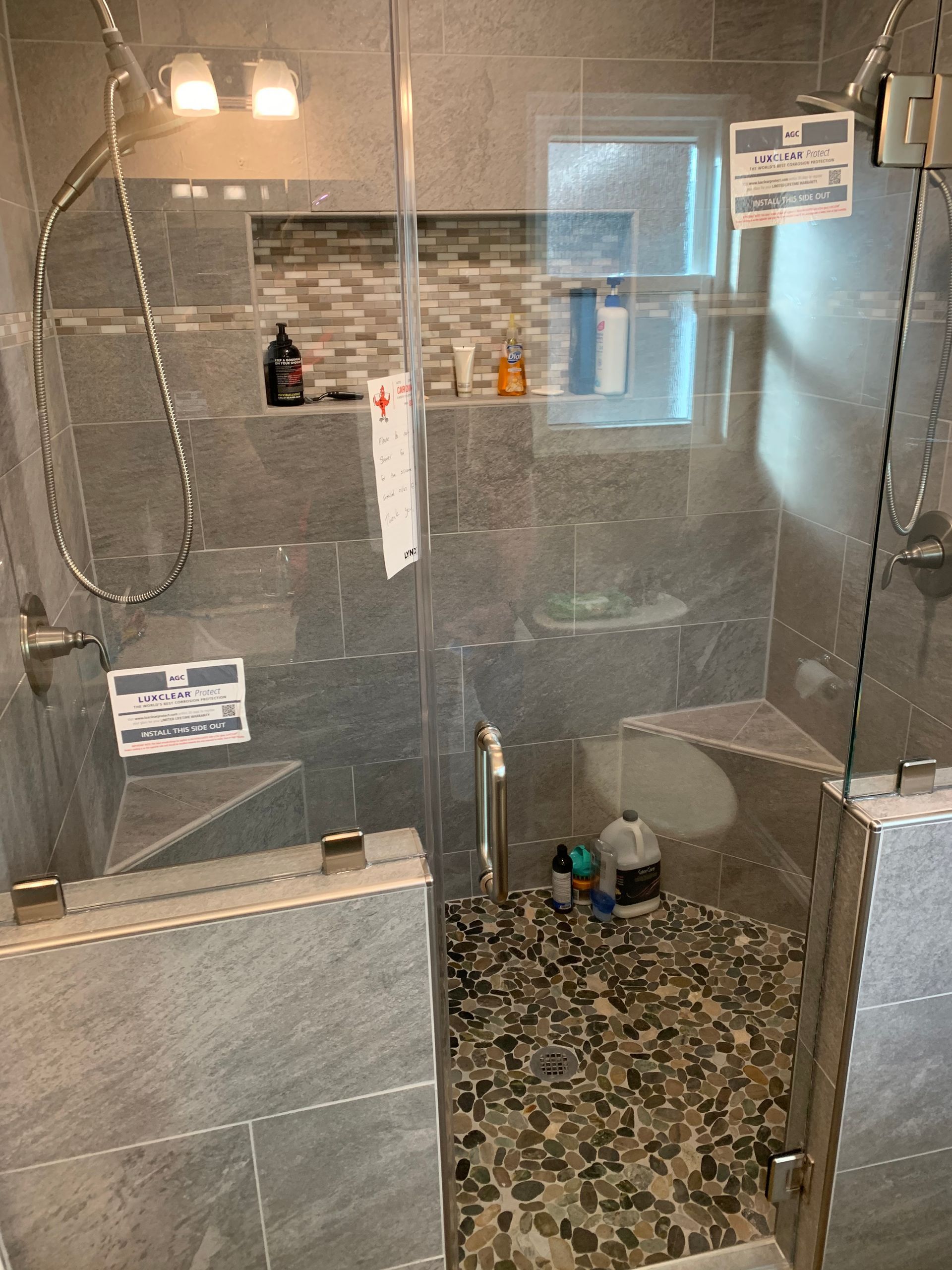 A bathroom with a walk in shower with a glass door.