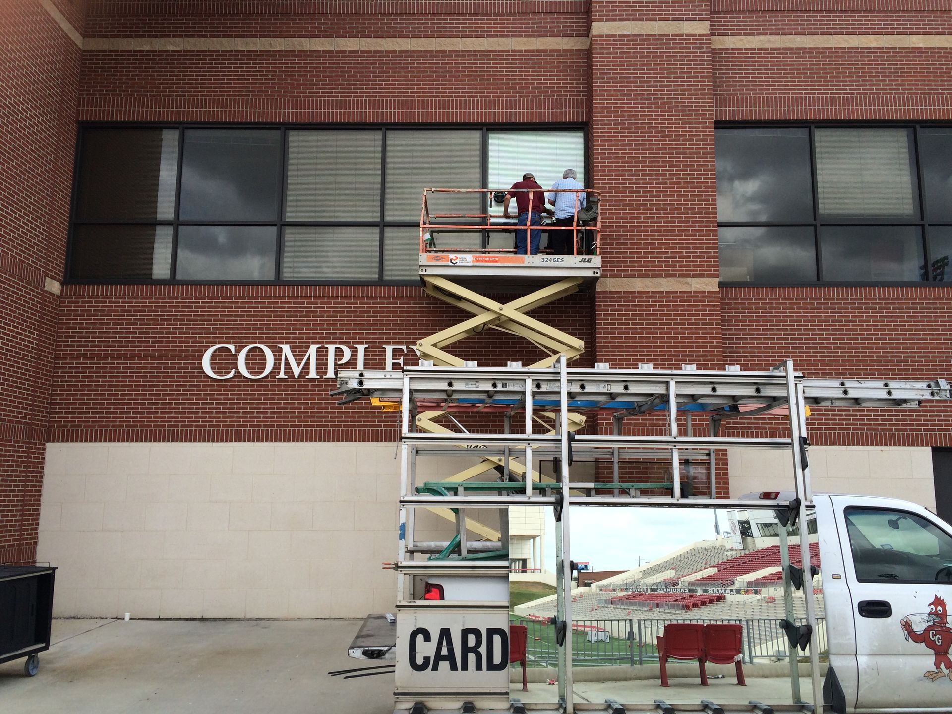 A white card truck is parked in front of a brick building