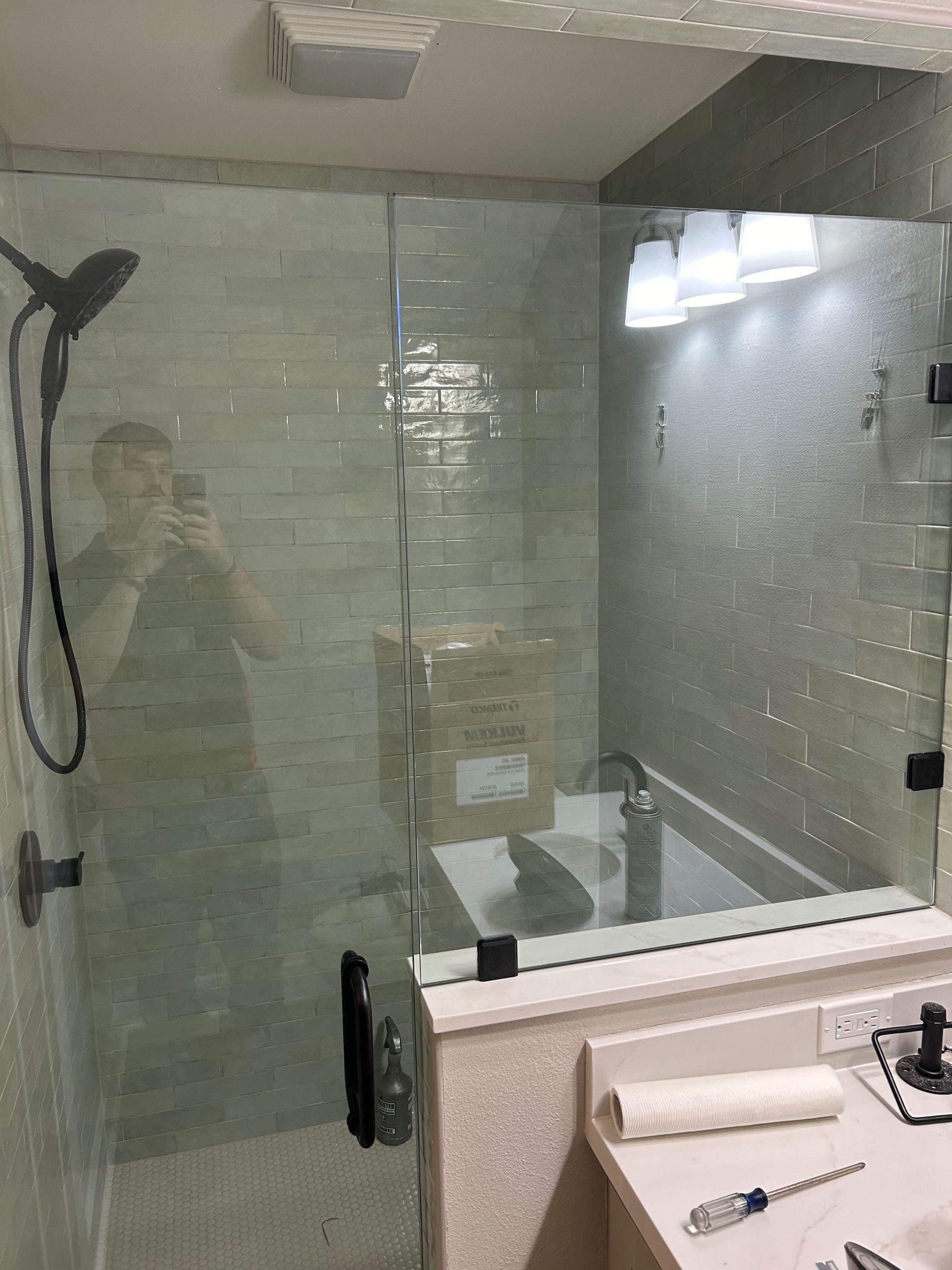 A bathroom with a shower , sink , and mirror.
