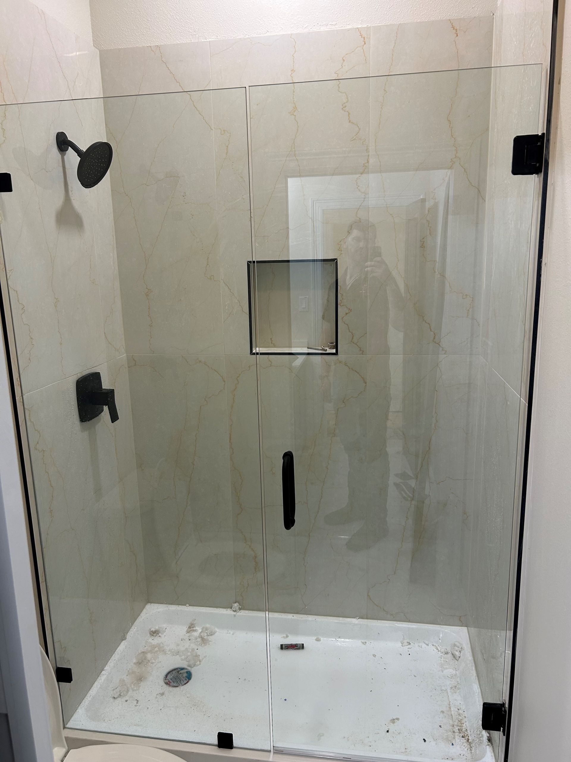 A bathroom with a shower stall and a shower head.