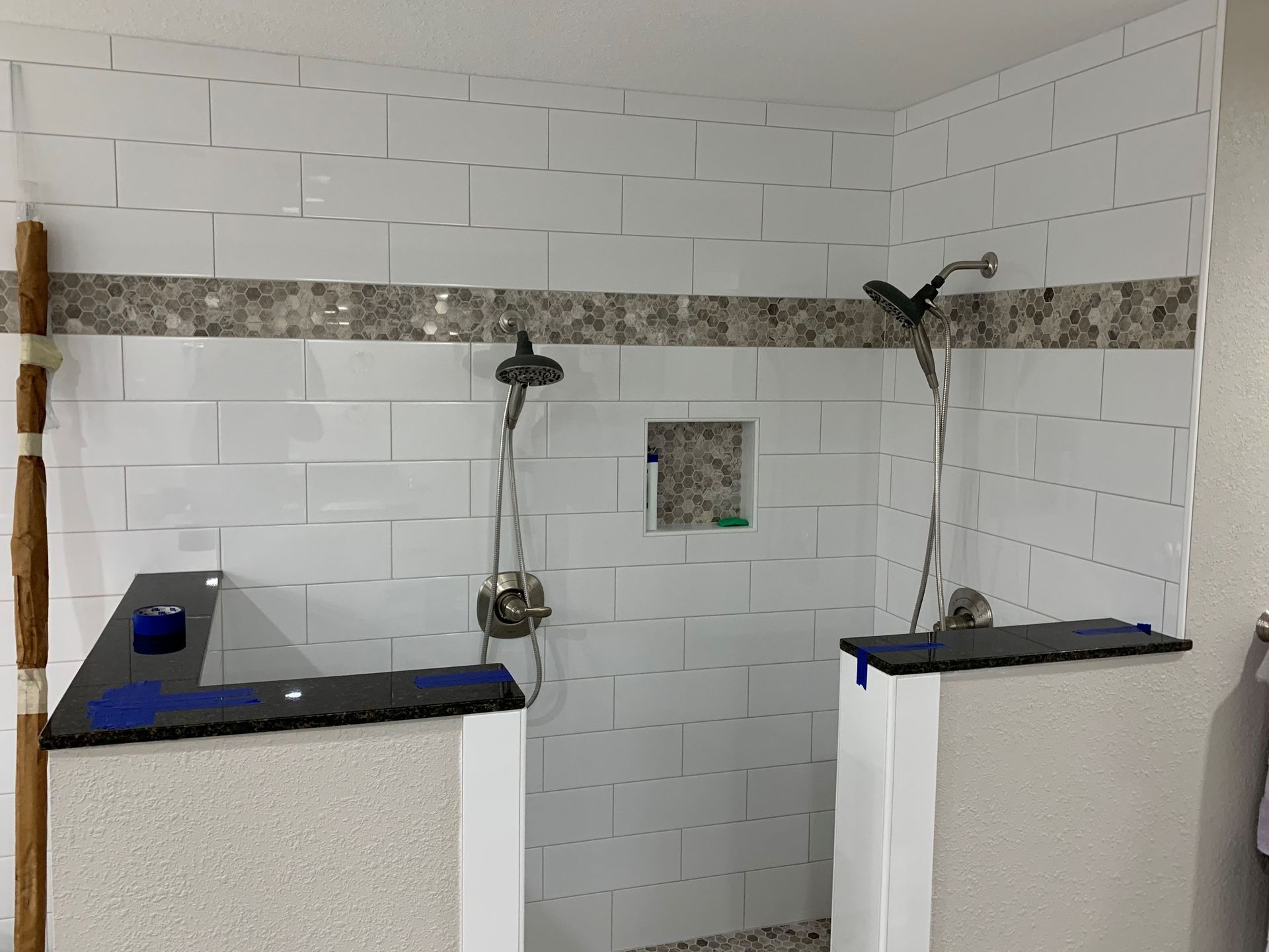 A bathroom with two showers and a sink.