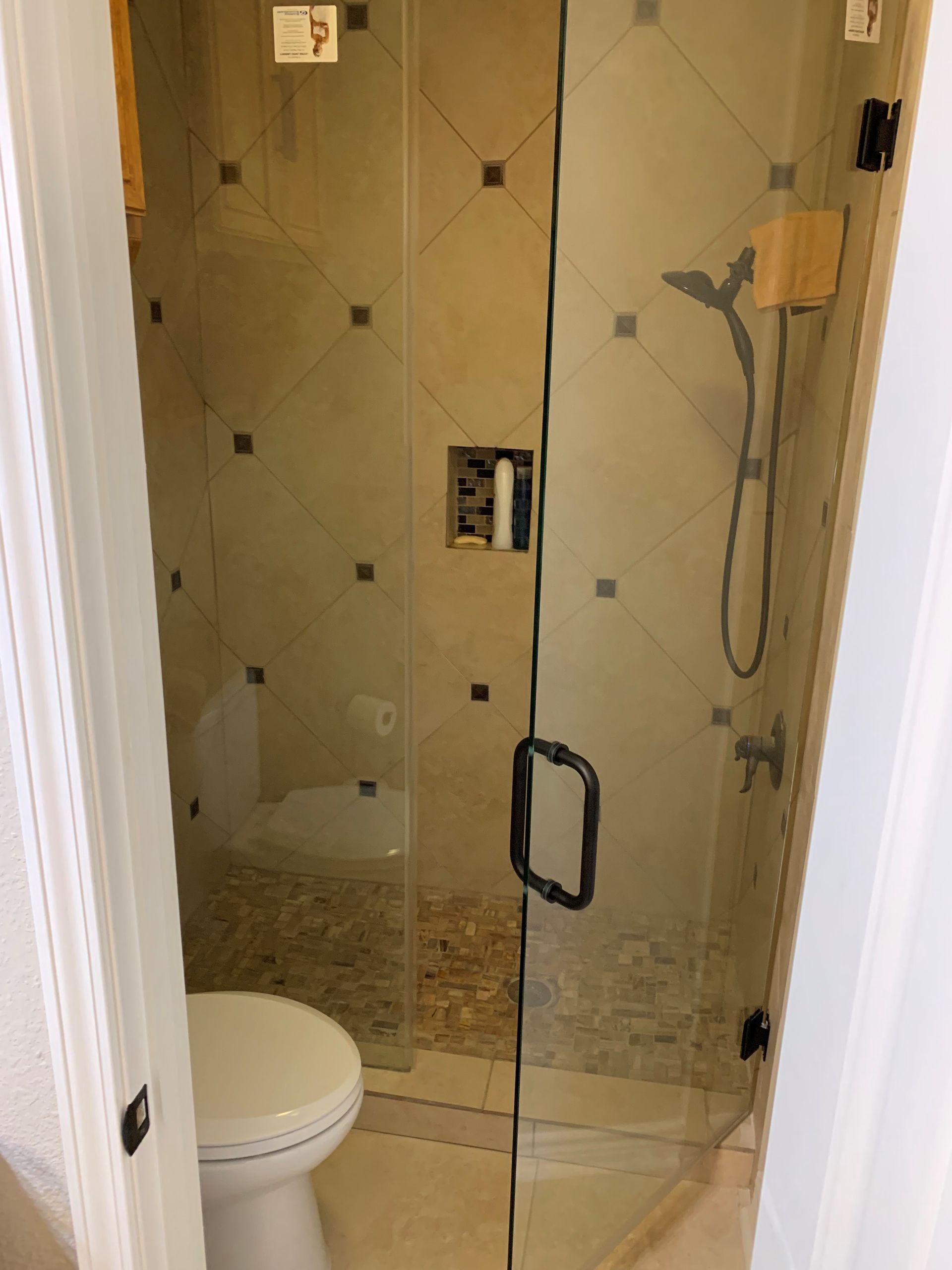 A bathroom with a toilet and a shower with a glass door