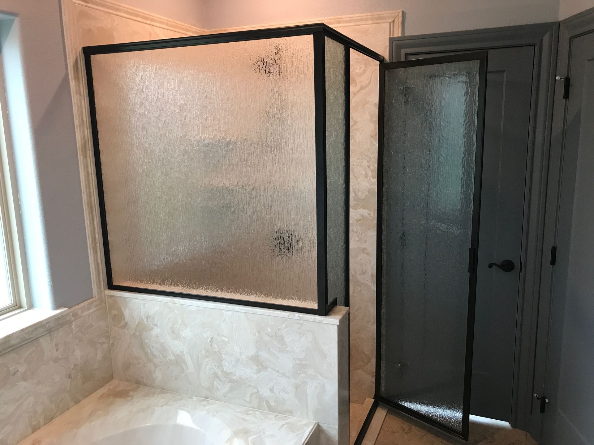 A bathroom with a walk in shower and a bathtub.