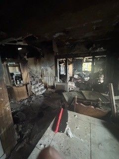A damaged house with charred surfaces and smoke residue