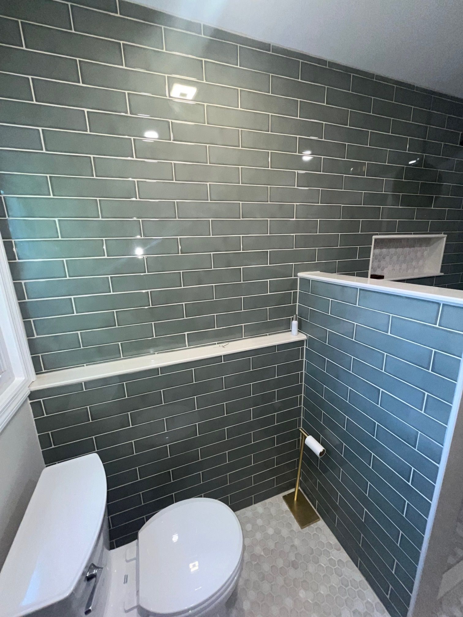A bathroom with a toilet, sink, and brick walls.