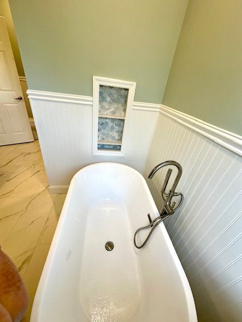 A bathtub with a faucet attached to it in a bathroom.