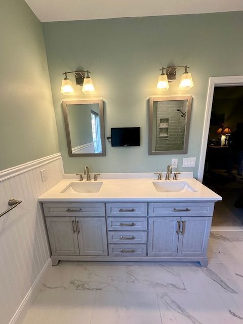 A bathroom with two sinks and two mirrors.
