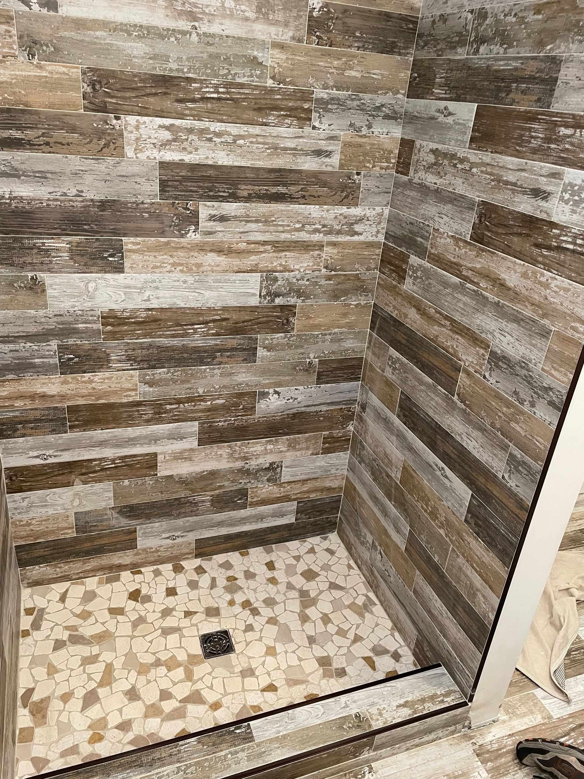 A shower stall with a wooden wall tiles