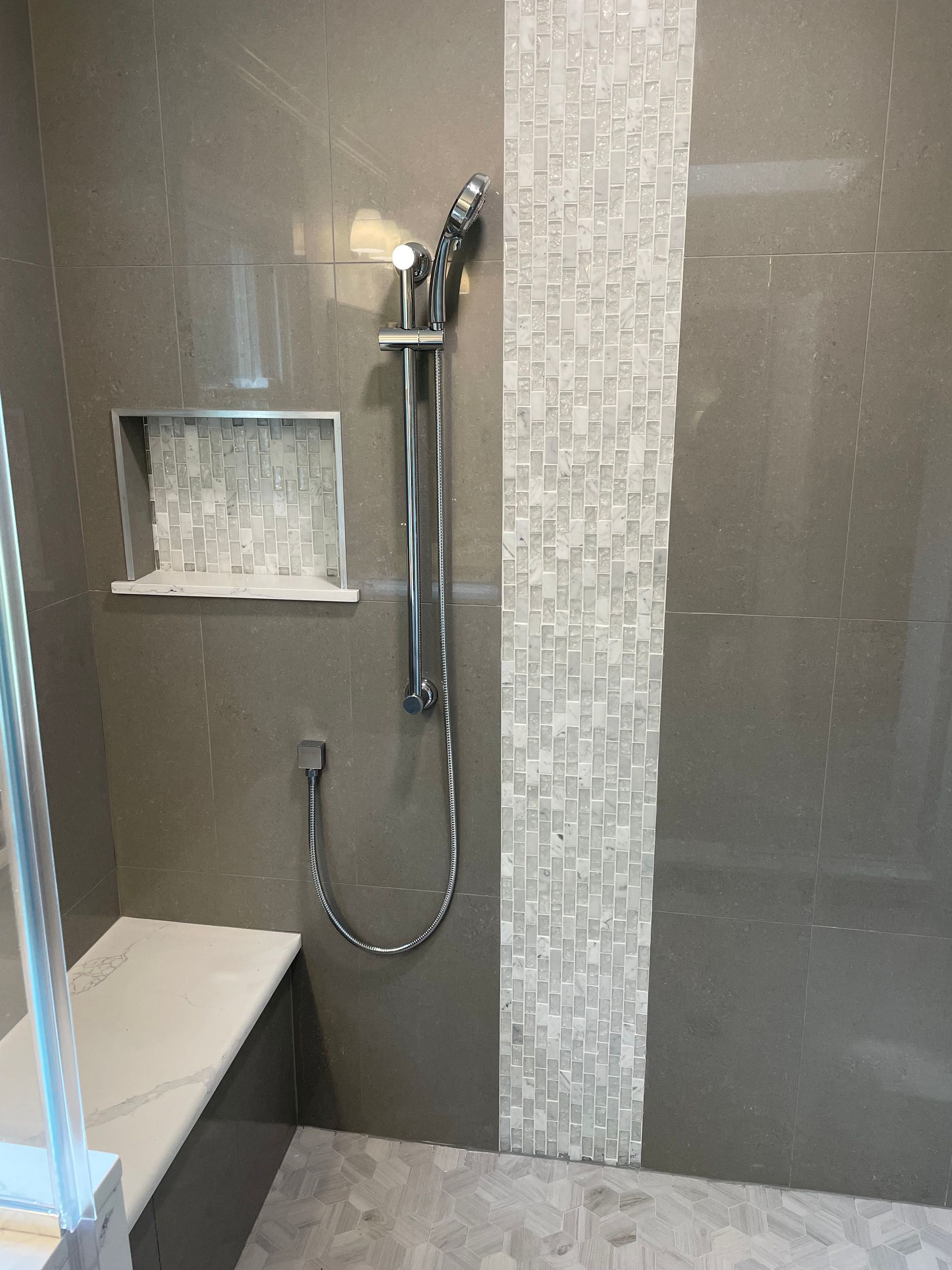 A bathroom with a walk-in shower and a bench
