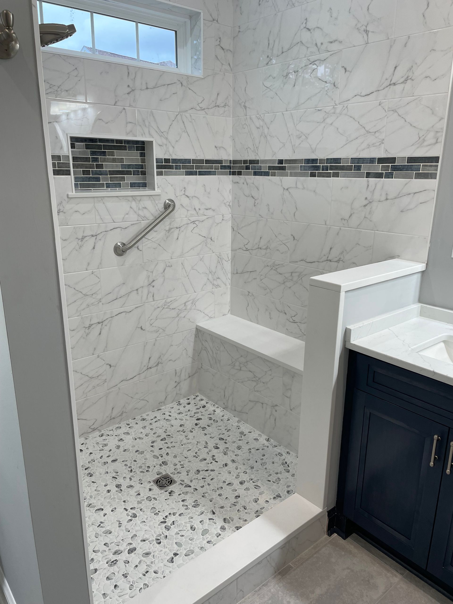 Walk-in shower with different tiles and a sink