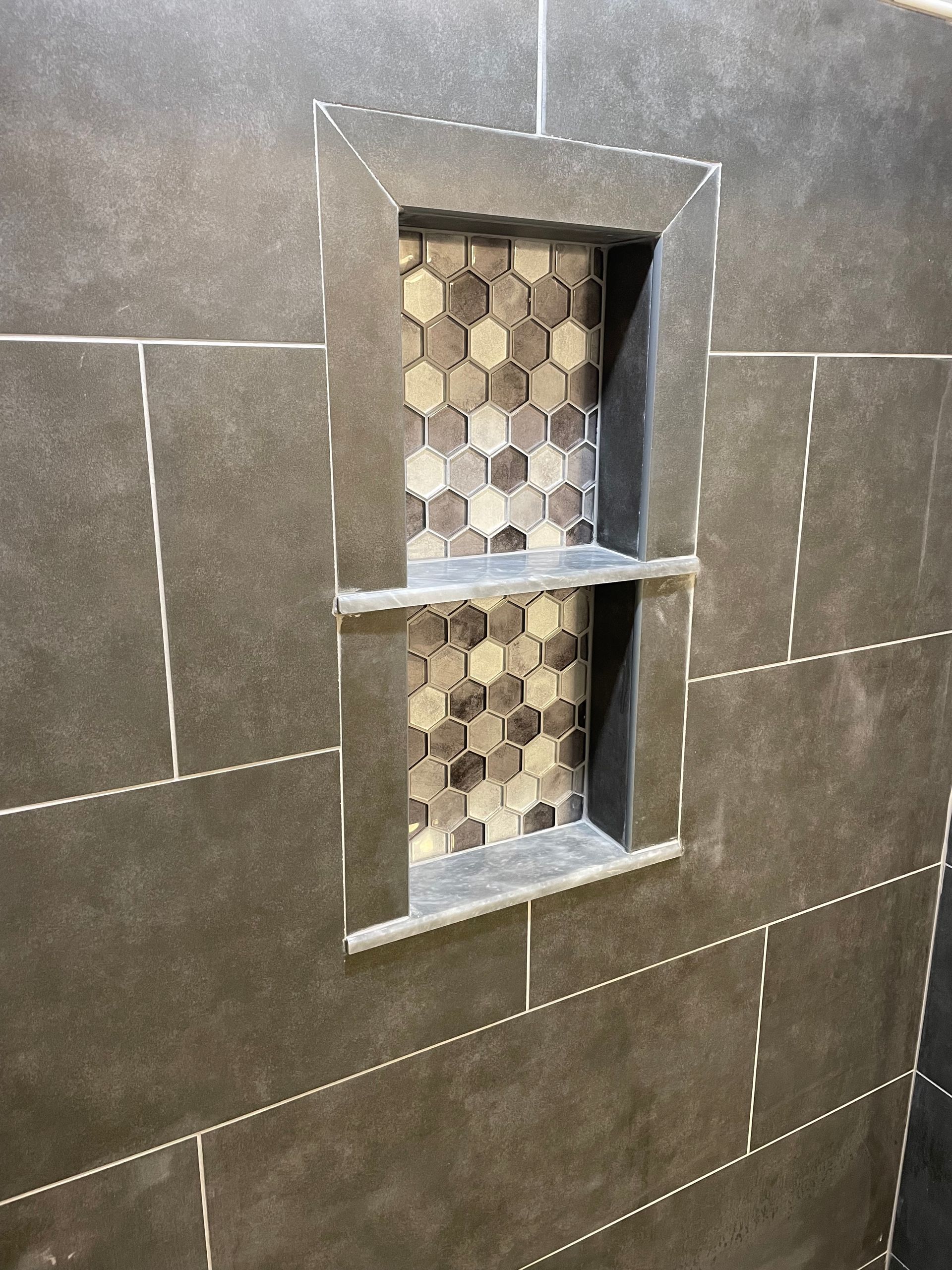 A shower stall with two shelves