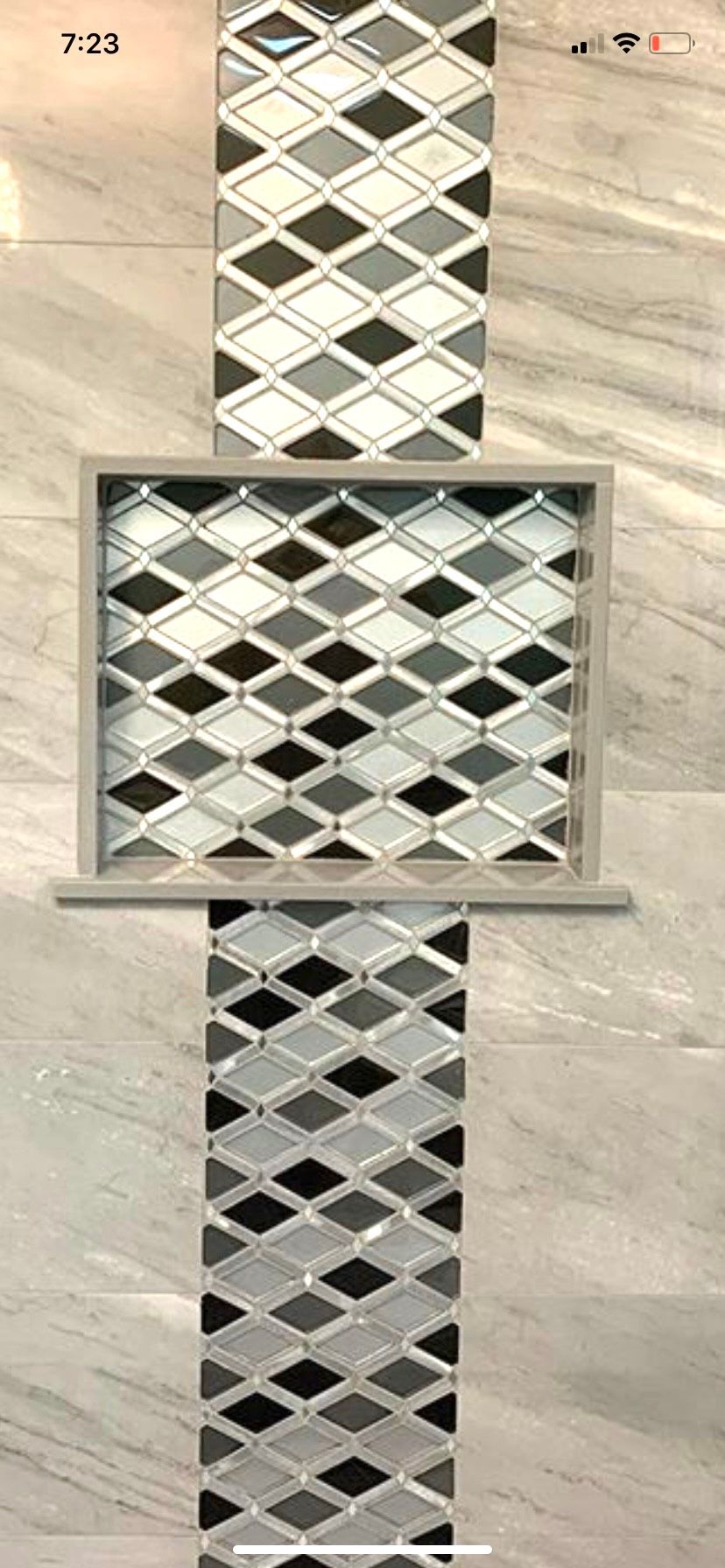 A close up of a tile wall with a diamond pattern on it